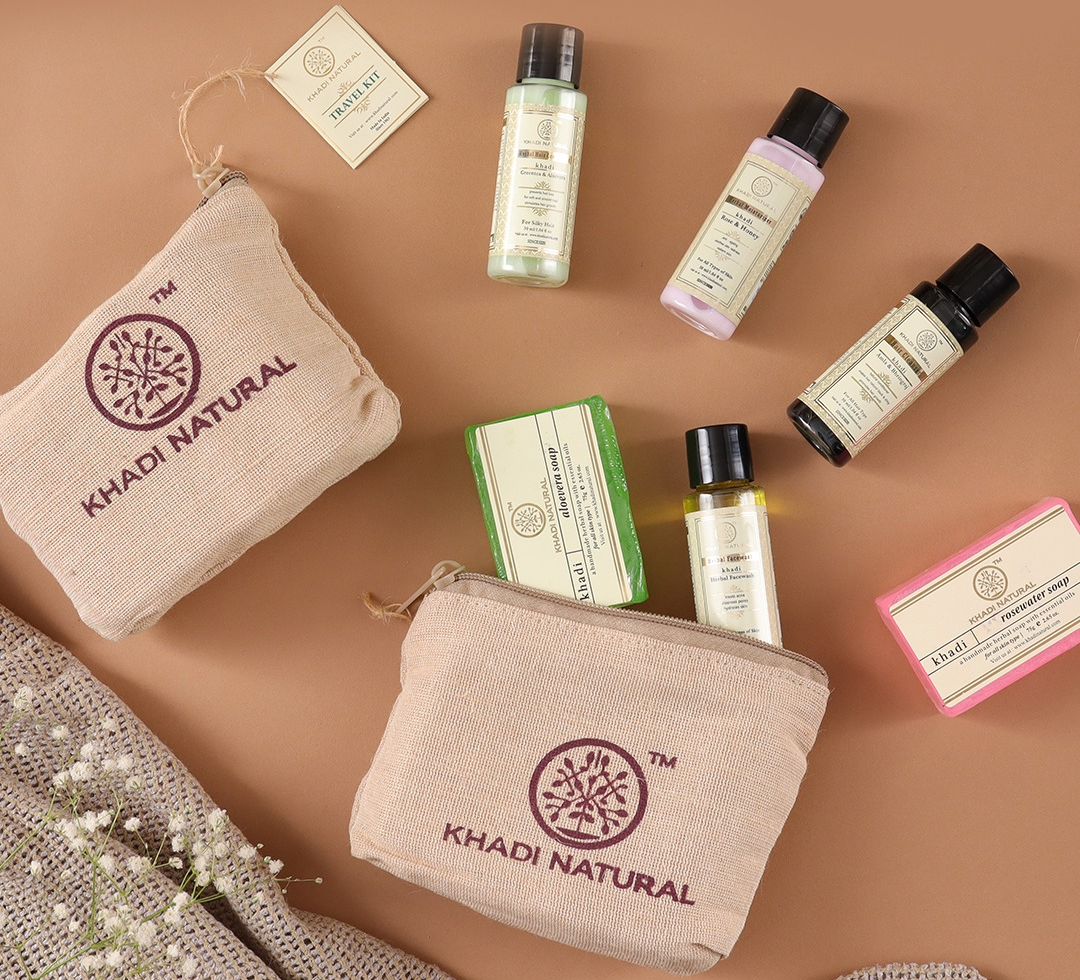 Khadi Natural Herbal Travel Kit with jute pouch, soaps, shampoo, conditioner, face wash and moisturizer displayed with aloe vera leaves